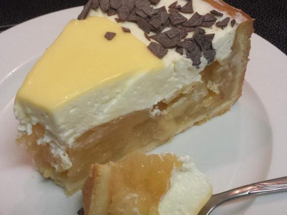 Stück von Apfelweintorte mit Äpfeln, Sahne und Eierlikör - dekoriert mit Schokoladen-Streuseln